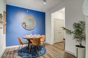 a dining room with a table and chairs and a blue wall